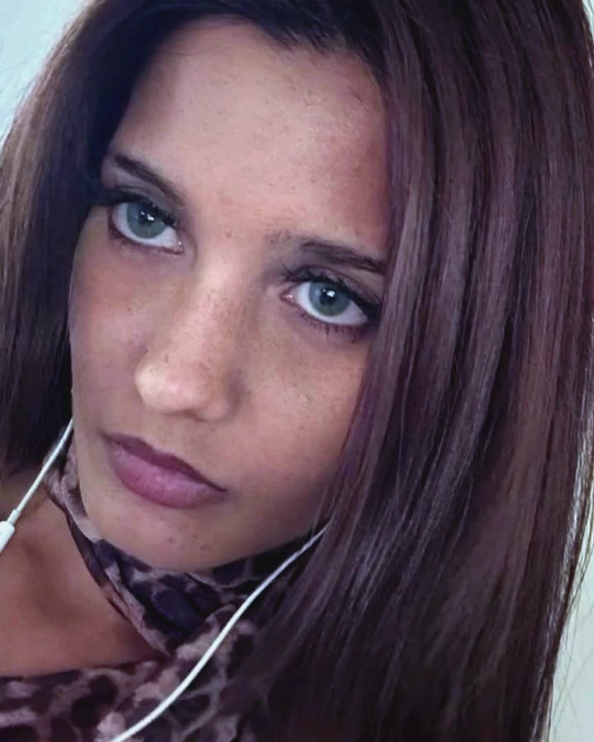 Close-up of a woman with blue eyes and long brown hair